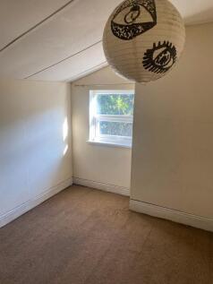 Cozy single bedroom featuring a window that bri...