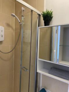 This modern bathroom features a sleek glass sho...