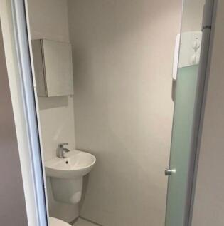 A modern and tidy bathroom with a shower, perfe...