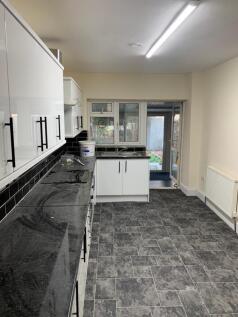 Spacious kitchen featuring sleek black countert...
