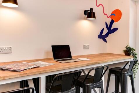 Bright and inviting communal workspace featurin...