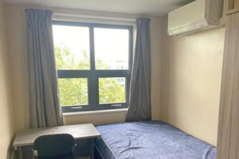 A bright and tidy double bedroom with a desk an...