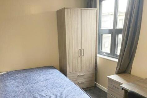A tidy and well-lit double bedroom featuring a ...