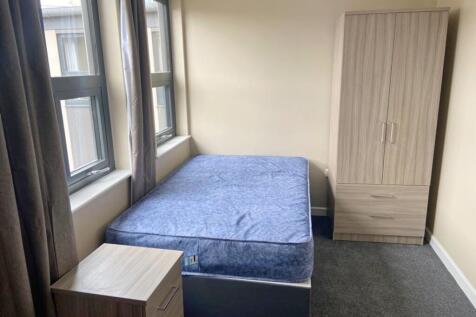 A cozy double bedroom featuring large windows t...