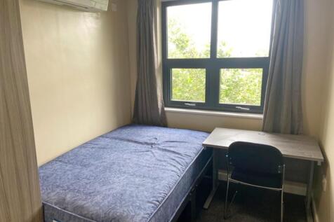 This cozy double bedroom features ample natural...