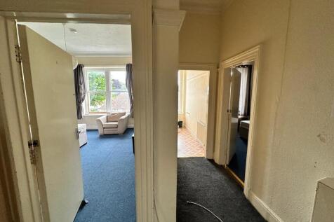 A spacious and well-lit hallway connecting vari...