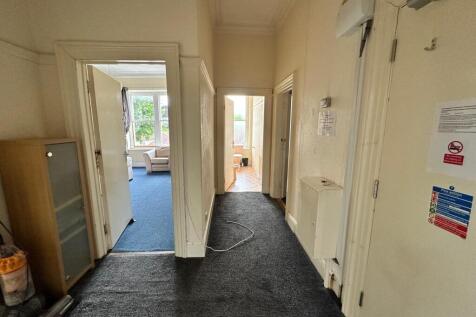 A bright and tidy hallway leading to various ro...