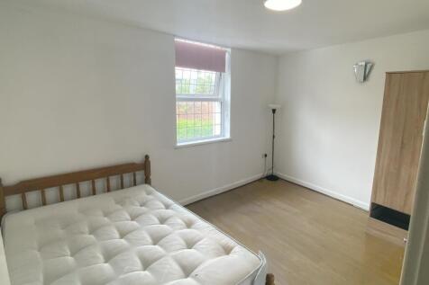 A bright double bedroom featuring a comfortable...
