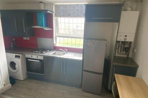 A modern kitchen featuring sleek blue cabinets,...