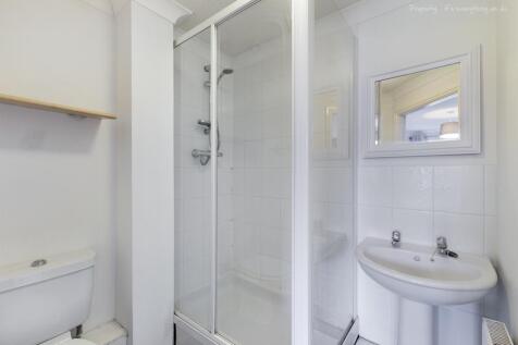 This modern bathroom features a spacious walk-i...