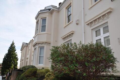 A charming exterior view of a cream-colored ter...