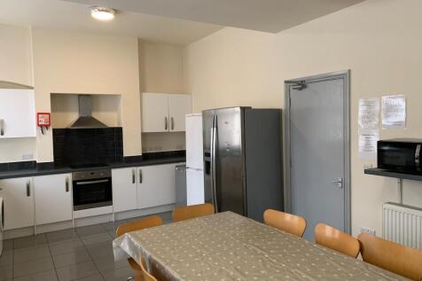A modern communal kitchen featuring ample seati...