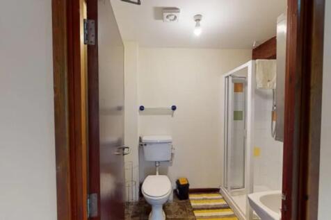 A tidy and bright bathroom featuring a shower a...
