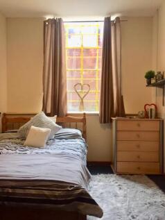 A cozy and inviting double bedroom with a large...