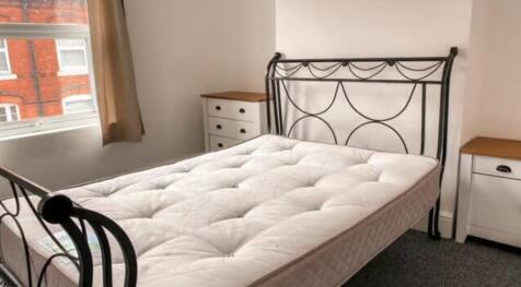 A bright double bedroom featuring a stylish met...