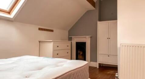 A cozy double bedroom featuring a bright skylig...