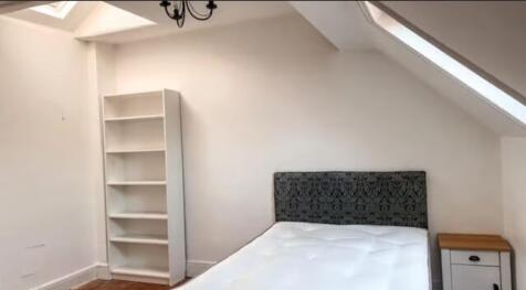 Bright attic double bedroom featuring a decorat...
