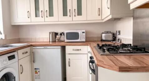 Bright and tidy kitchen featuring modern wooden...