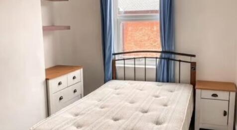 A bright double bedroom featuring a comfortable...