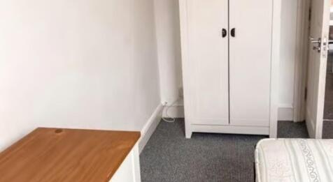 A neat and functional single bedroom featuring ...