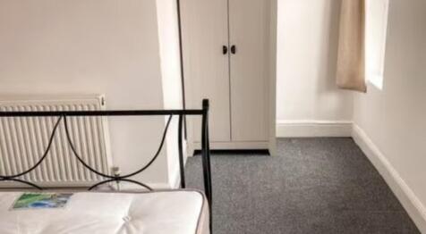 A neat and tidy single bedroom featuring a meta...