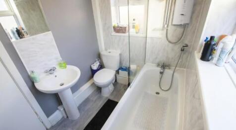 Bright and clean bathroom suite featuring a mod...