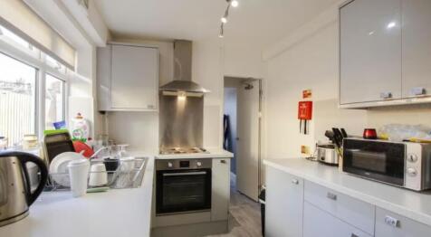 Bright and modern kitchen featuring sleek white...