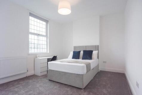 Bright and fresh master bedroom featuring a com...