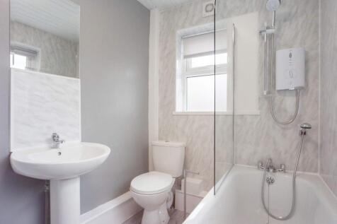 Bright and clean bathroom suite featuring a mod...