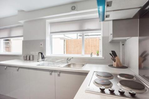 Bright and modern kitchen featuring sleek white...