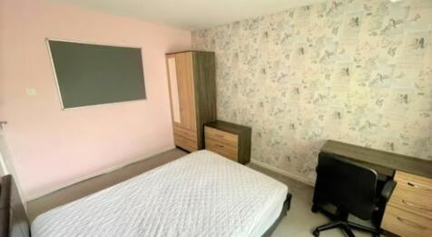 Bright and tidy master bedroom featuring a comf...