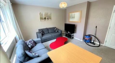 A cozy living room featuring two comfortable gr...