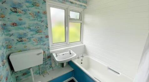 A bright bathroom suite featuring a white batht...