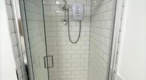 Modern, clean shower area featuring sleek white...