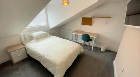 A cozy and well-maintained bedroom featuring a ...