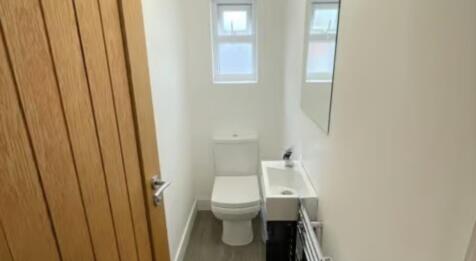 A bright and clean single toilet featuring mode...