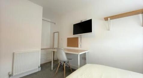 A neat and functional single bedroom featuring ...