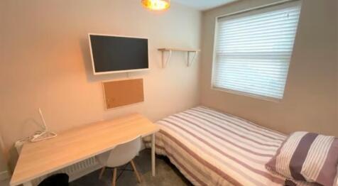 A neat and welcoming single bedroom featuring a...