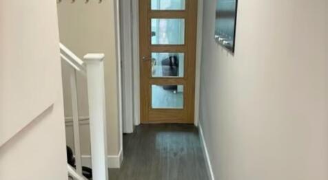 A clean and modern hallway featuring a wooden f...