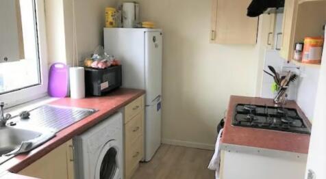 Compact kitchen featuring essential appliances ...