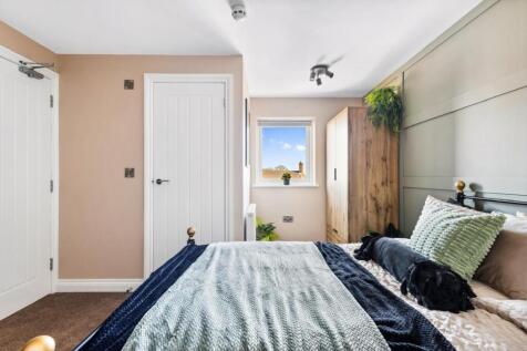 This inviting double bedroom features a cozy be...