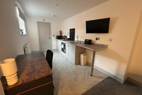 Modern kitchenette featuring sleek countertops,...