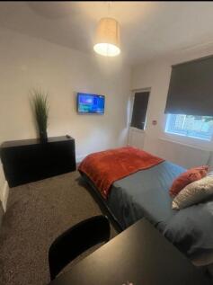 A neat and cozy single bedroom featuring a comf...