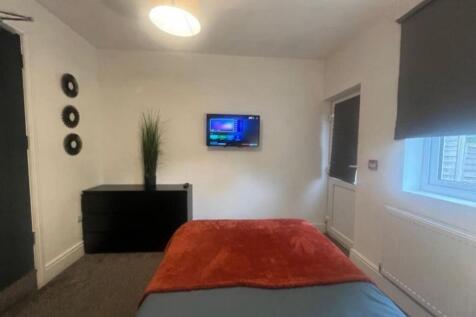 A cozy single bedroom featuring a comfortable b...