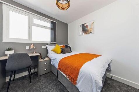 A bright and neatly arranged single bedroom fea...