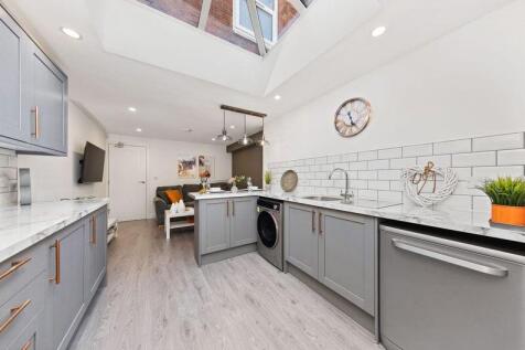 Bright and modern kitchen featuring stylish gre...