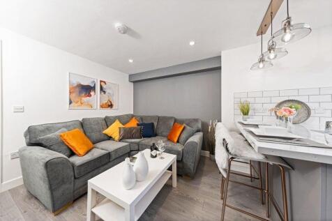 A modern and cozy living room featuring a spaci...