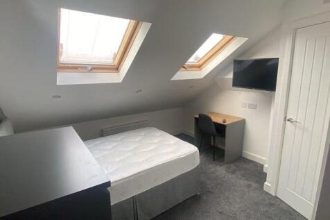 A clean and modern single bedroom featuring two...