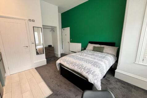 This inviting double bedroom features a cozy la...