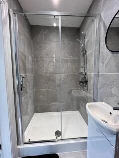 This modern bathroom features sleek grey tiles ...